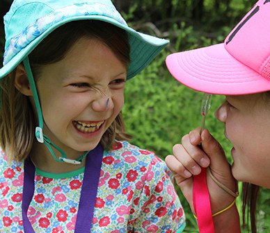 Lucy holds a hand lens up to her eye. Photo: Land Trust.