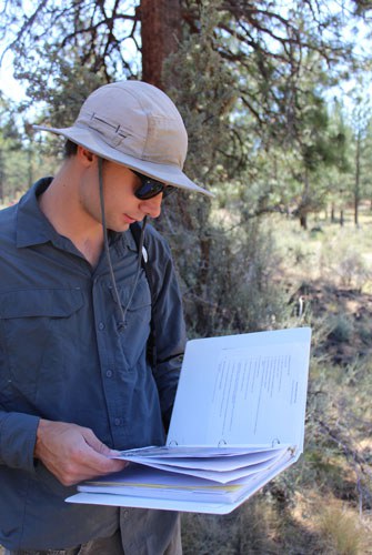 Taking a look at the monitoring notebook while out in the field. Photo: Land Trust.