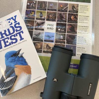 A birding guidebook, bird bingo, and binoculars from the Library of Things birding kit created by Deschutes Land Trust. Photo: Land Trust.